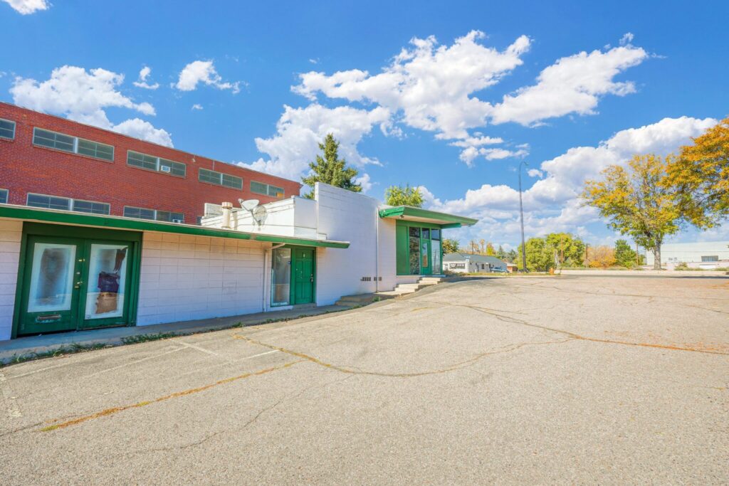 Exterior of 8700 W Colfax Ave in Lakewood, Colorado - single-story multi-tenant office building with surface parking