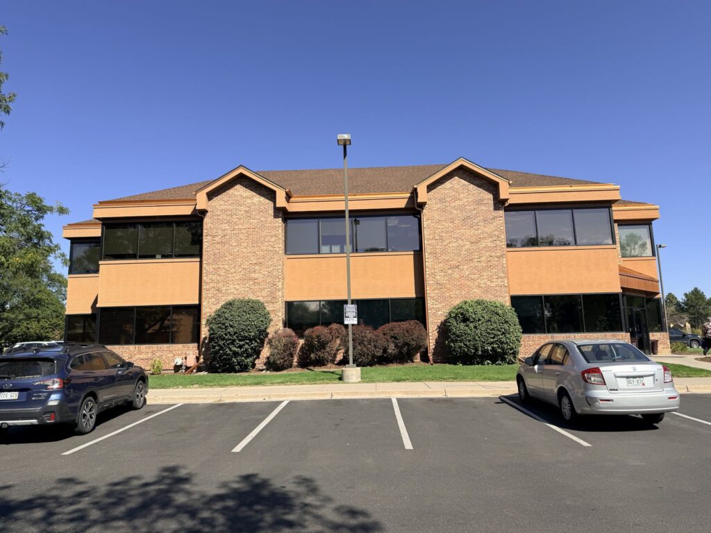 Front of the building with brick gables and parking along W South Boulder Rd
