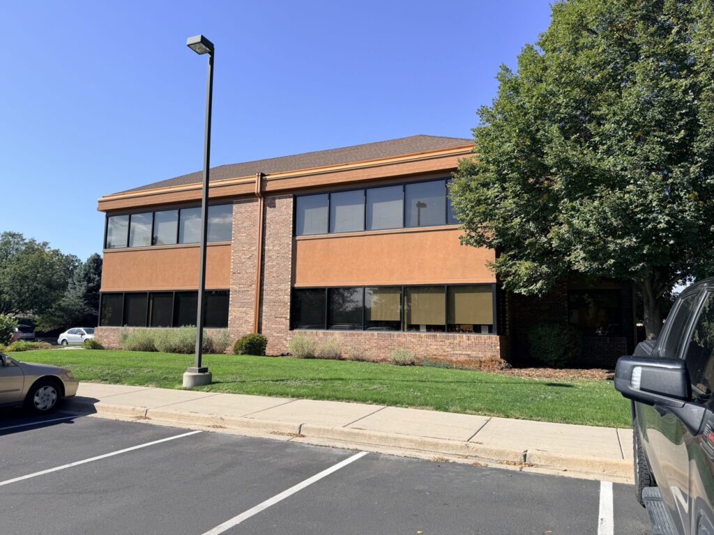Side of the building with a lawn and mature shade tree